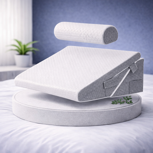 Coussin ergonomique incliné avec rouleau de soutien détachable présenté sur un socle dans une chambre lumineuse.